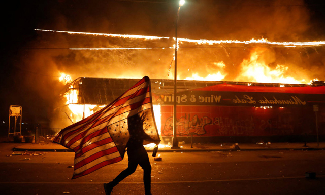 "It had been a tense, challenging Thursday evening in the riot-torn Twin Cities for Associated Press photographer Julio Cortez. Midnight was fast approaching, and so was a lone protester carrying an upside-down U.S. flag." - Boston.com